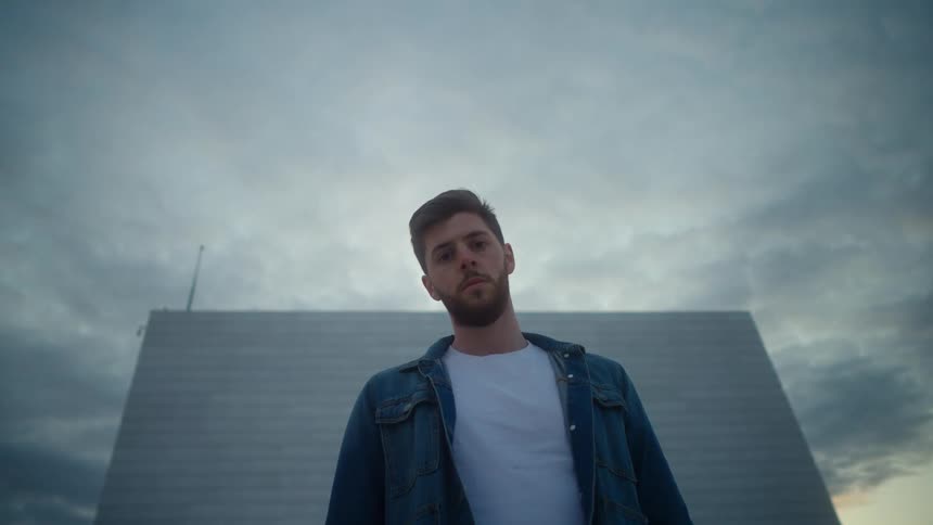 A man is posing in front of the building