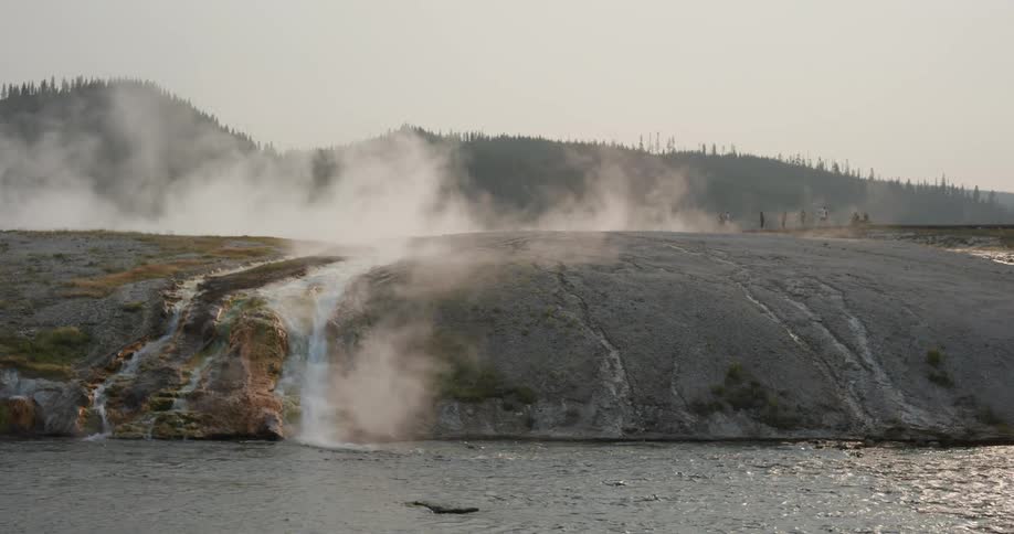 Steam rising from a stream flowing into a lake