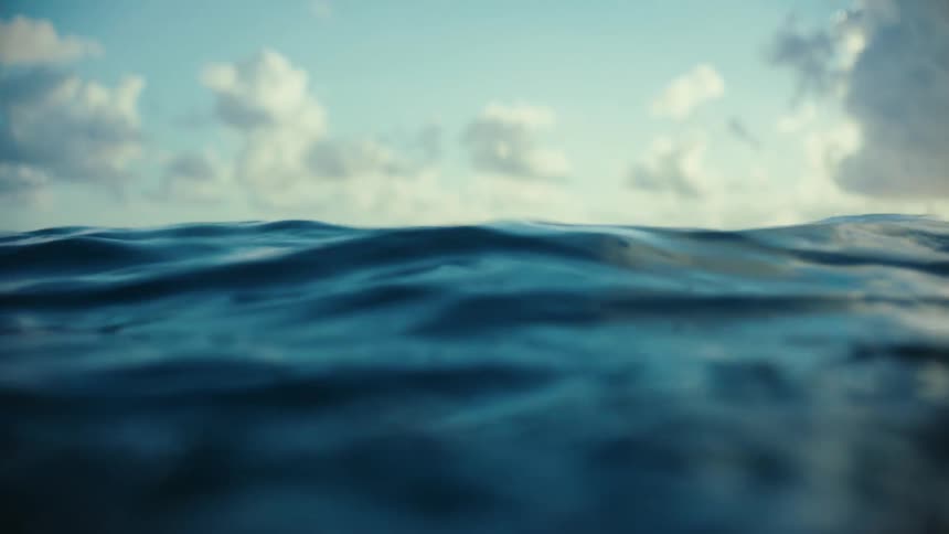 Sunlight shines on water as it ripples and waves under a cloudy sky