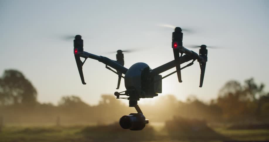 A drone flies over a grassy field