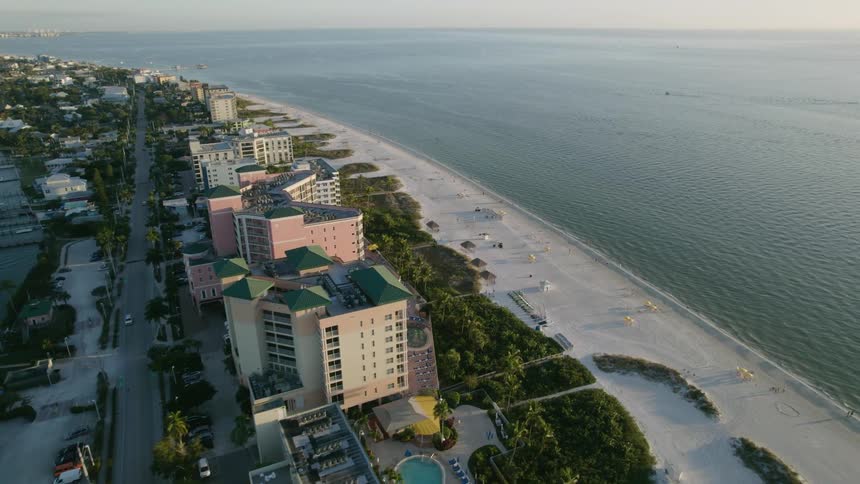 An aerial view of  Fort Myers Beach hotels with people walking and boats in the water