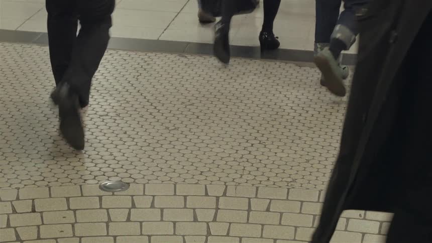 People walk on a tile floor
