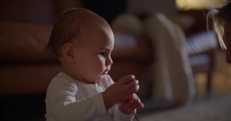 A father plays with a baby in a living room