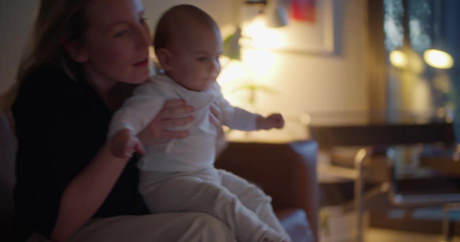 Baby plays with laptop and mother picks child up