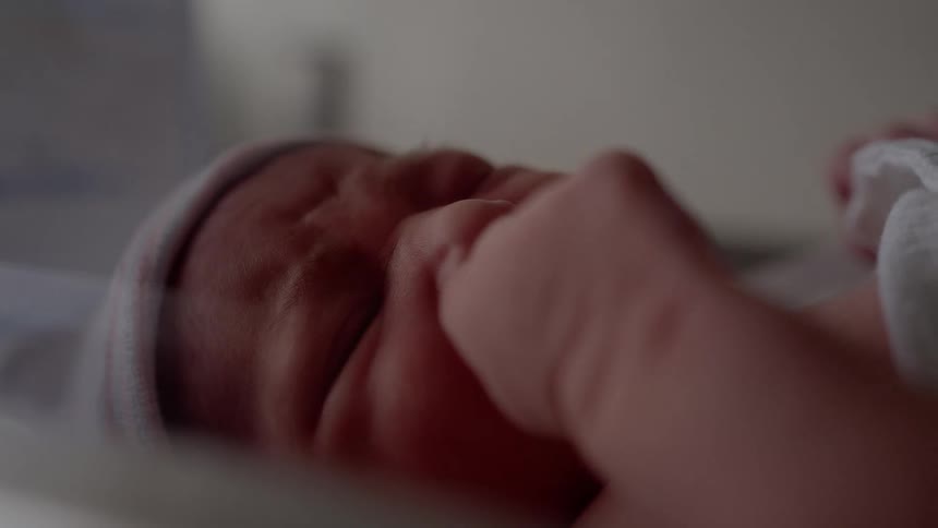 Newborn infant moves and cries while lying down