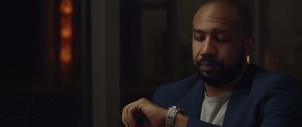A man is sitting in a room by himself at night