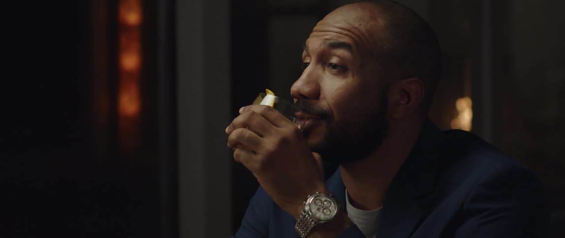 A man is drinking an alcoholic beverage indoors