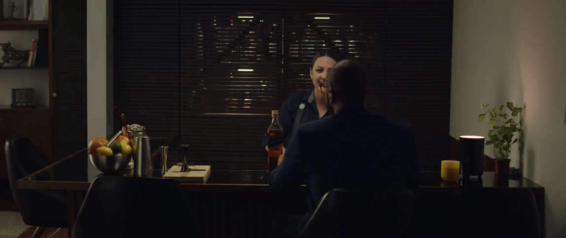 A female bartender serving a drink to a male patron