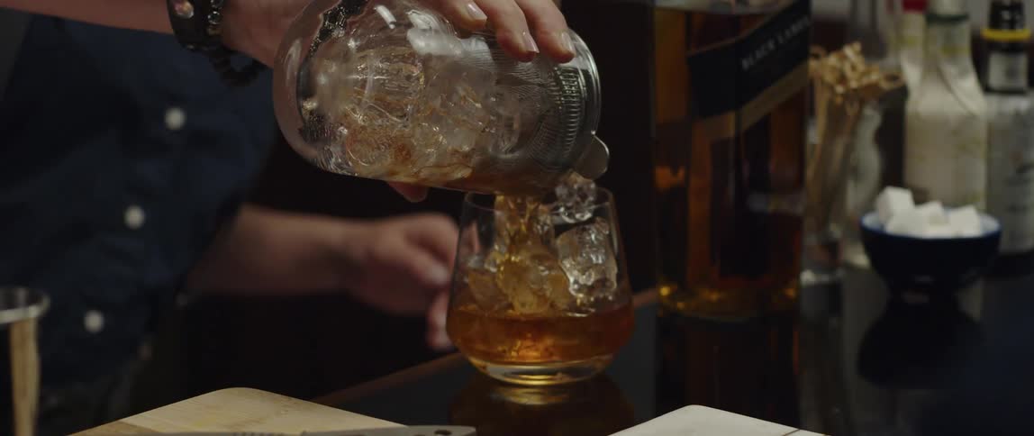 A bartender is making an alcoholic drink