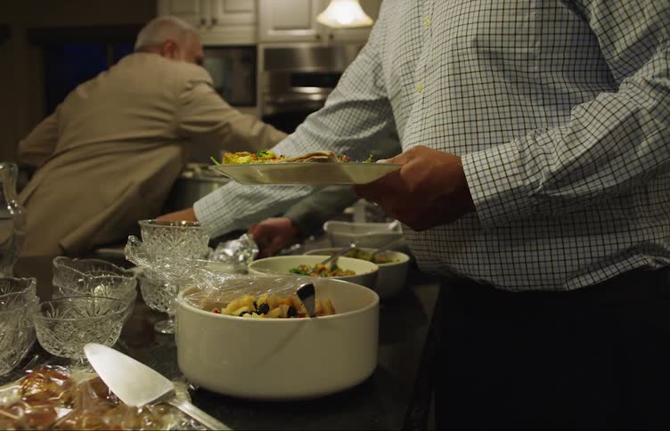 A family is getting a plate of food that was made at home