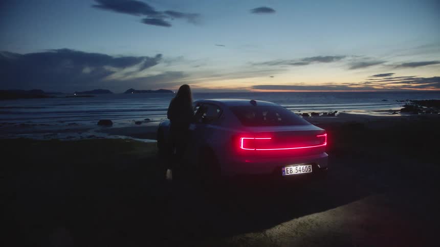 A person parked their car at a beach and walks towards the coast