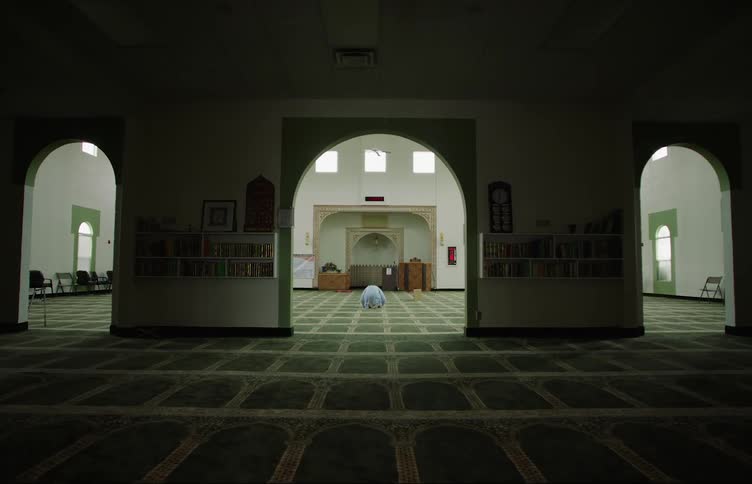 A person is praying inside of a mosque in the middle of the day