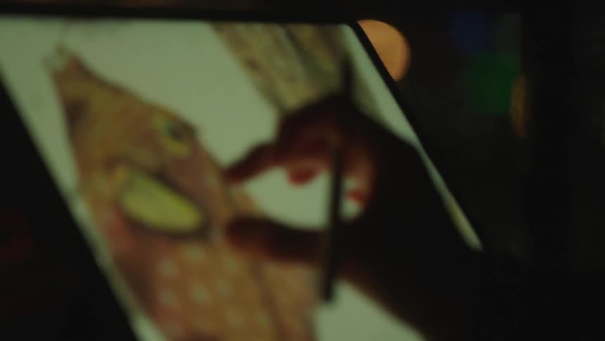 A woman zooms into an image of a fish on her tablet