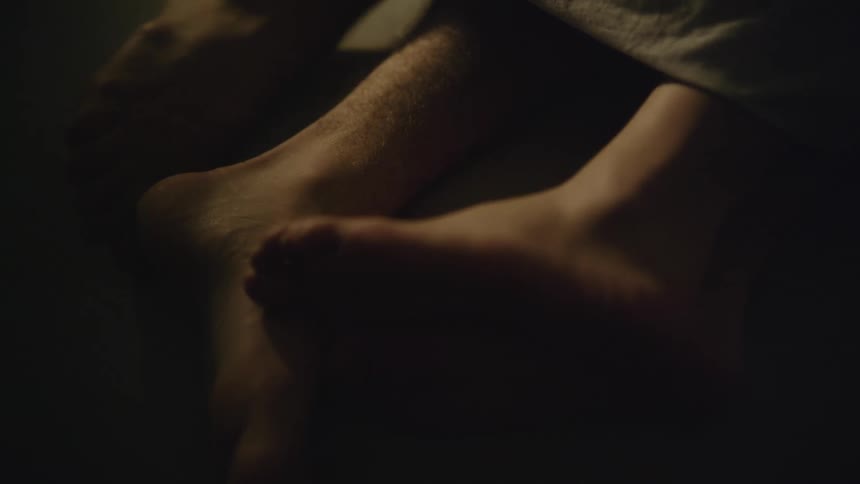 Feet are touching each other in the bed against each other