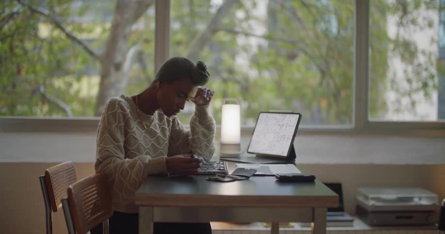 A woman is sitting at a table and using a computer