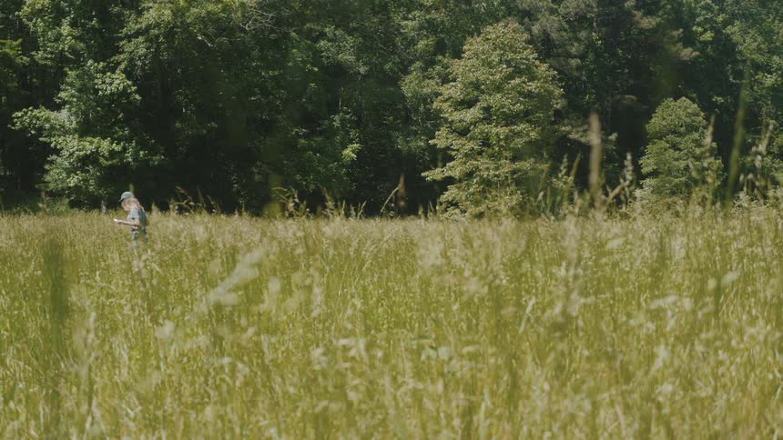 A person is walking through a field during the spring