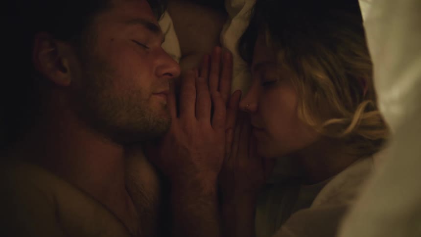 Young couple sleeping face to face under the blanket on the bed