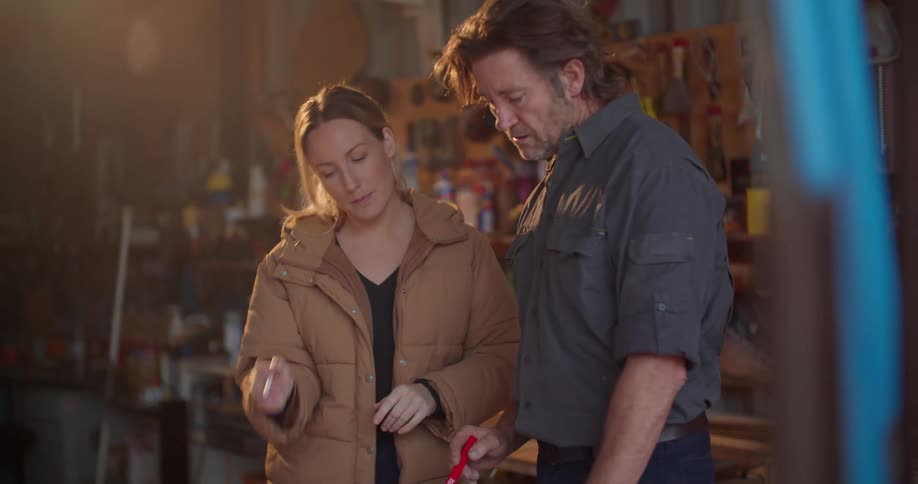 Contractors go over blueprints while in a garage