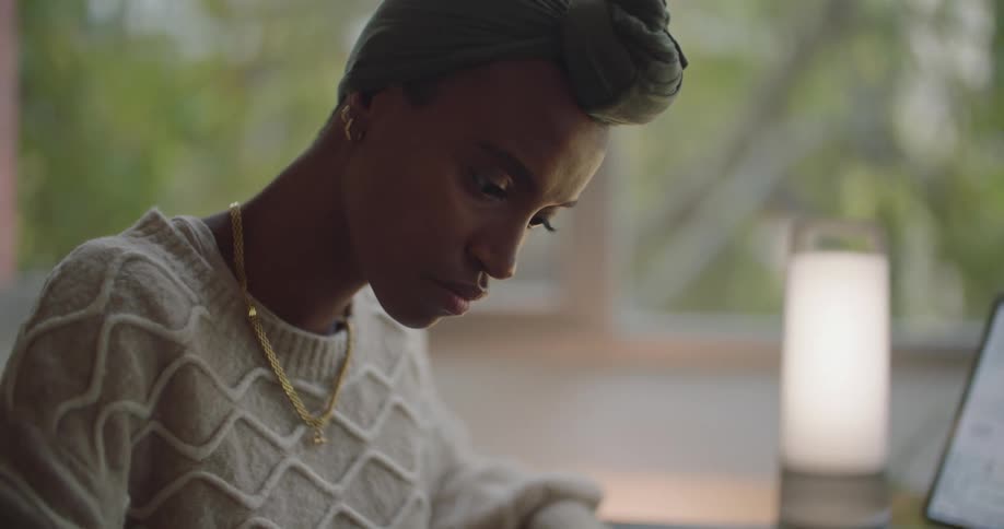 A young black woman is indoors and fixing something