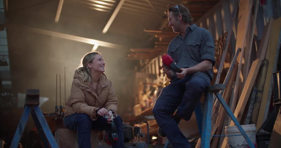 Contractors take a break and chat while sitting on sawhorses in a garage