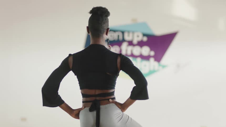 A young black woman is stretching inside