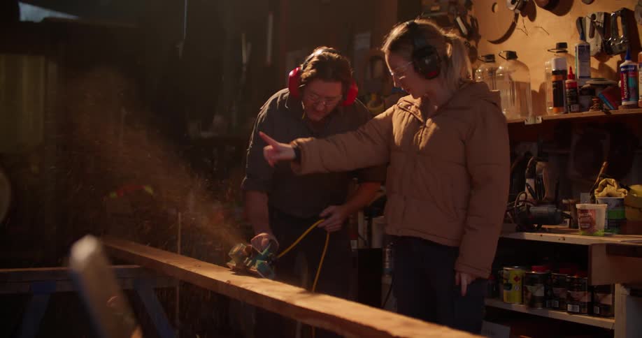 Two people are using tools to fix something inside
