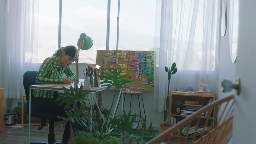 A woman sits in an office and writes
