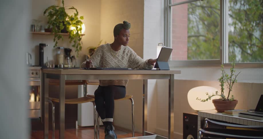 A woman is typing on her laptop and sitting at a table