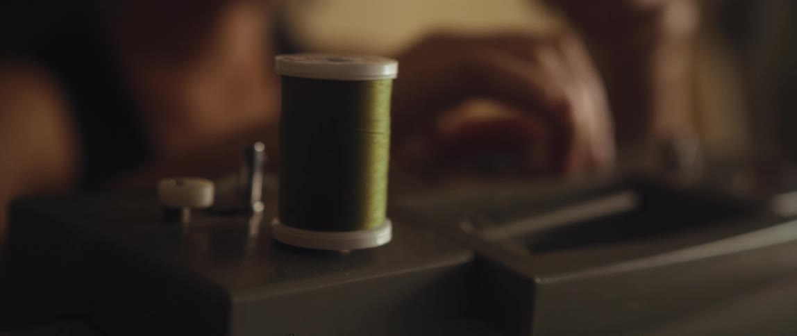 A woman is using a sewing machine inside