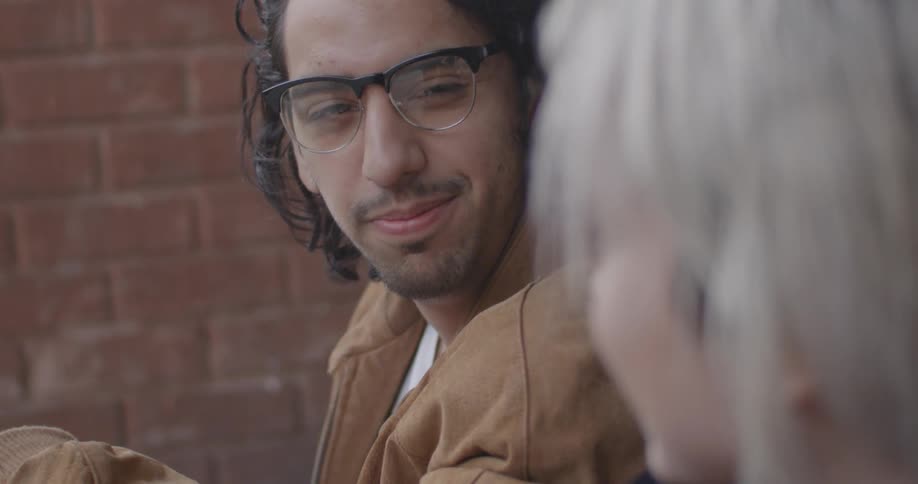 A man smiles as he talks to a woman