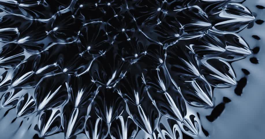 Protrusions appear on mass and wave about before mass submerges into black oily liquid