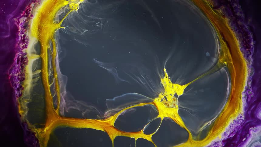 Bubble of yellow ink surrounded by purple expanding over a gray background