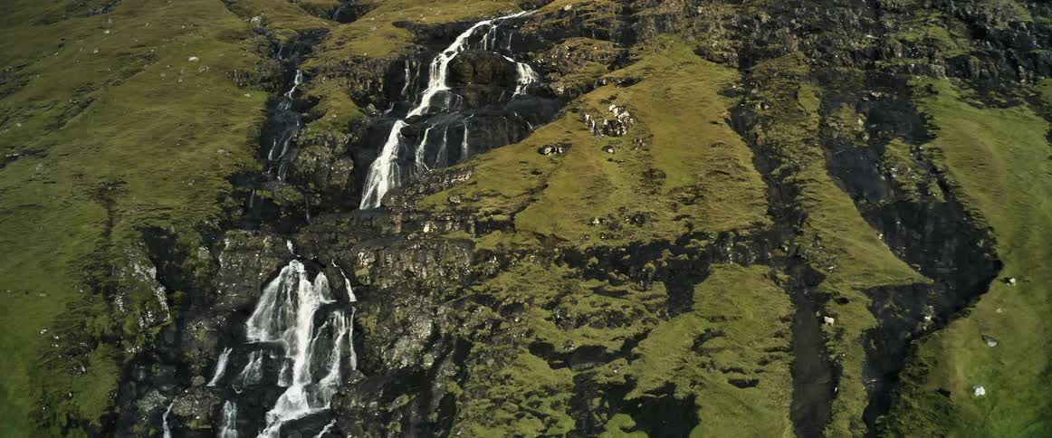 A waterfall river cascades down a mountain