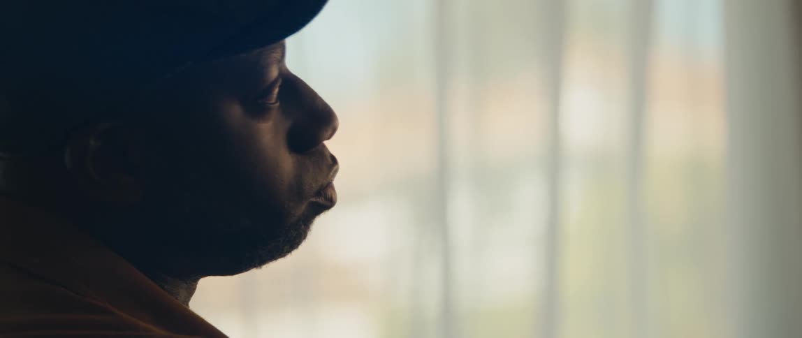 A young black man is singing inside the room