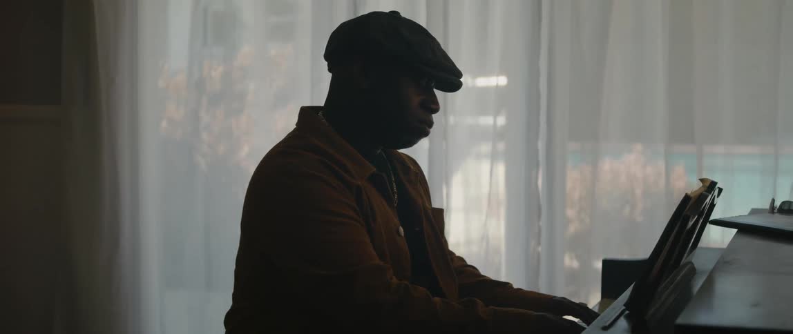 Young black man is playing the piano inside his house