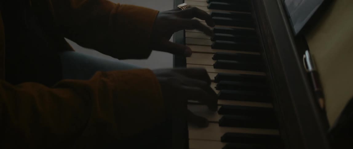 A musician is playing the piano in his house