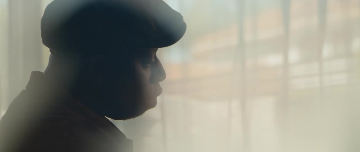 A man is sitting indoors near a window