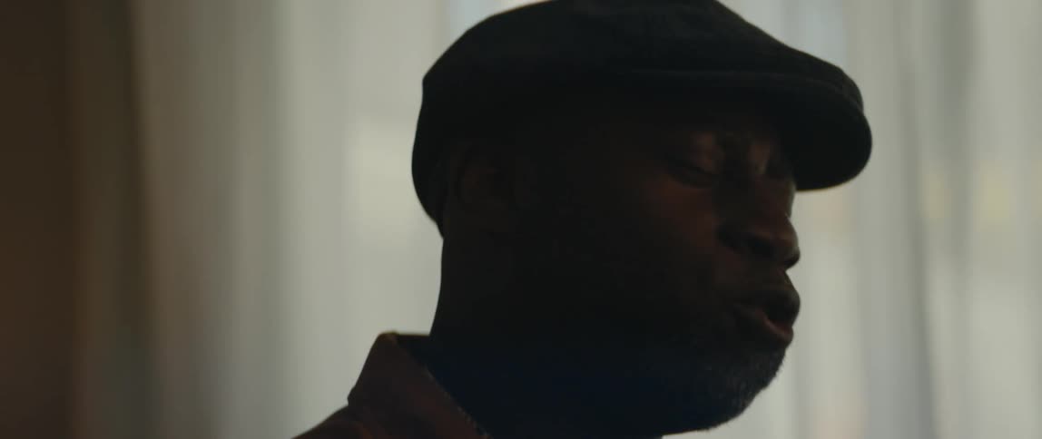 A young black man is singing inside of his home