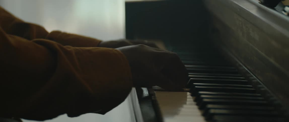 Close up view of a man playing a piano is displayed