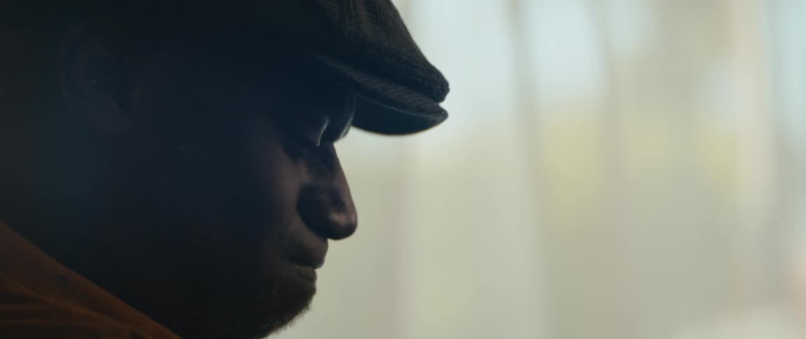 A man is wearing a hat and smiling indoors