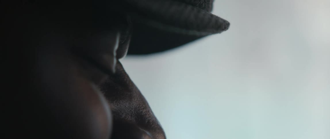 Close up view of a man wearing a hat is displayed