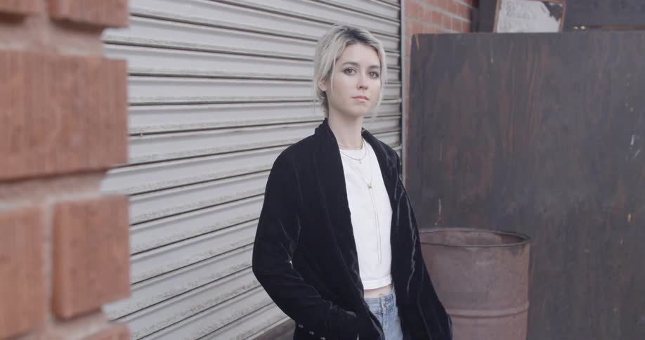 A woman is standing near a gate outside