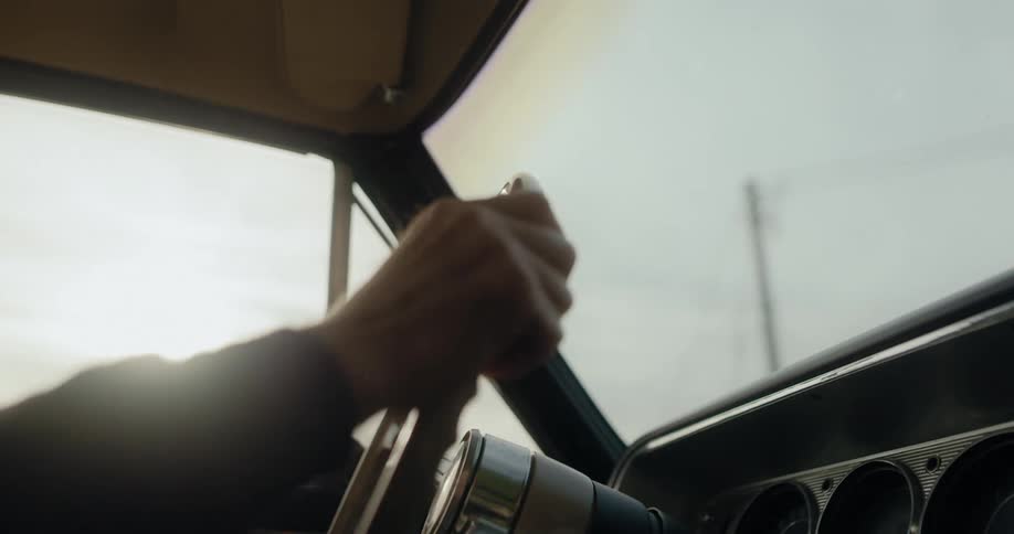 A person is driving a vehicle while the sun is setting