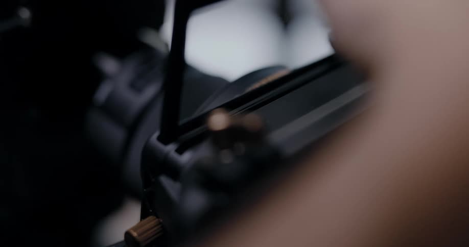 A person adding a lens to a camera