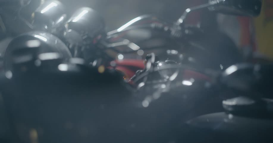 Motorcycles sit parked in dimly lit room
