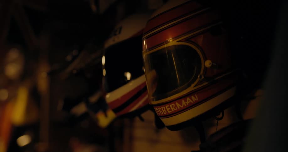 Helmets are hanging on shelves in a garage
