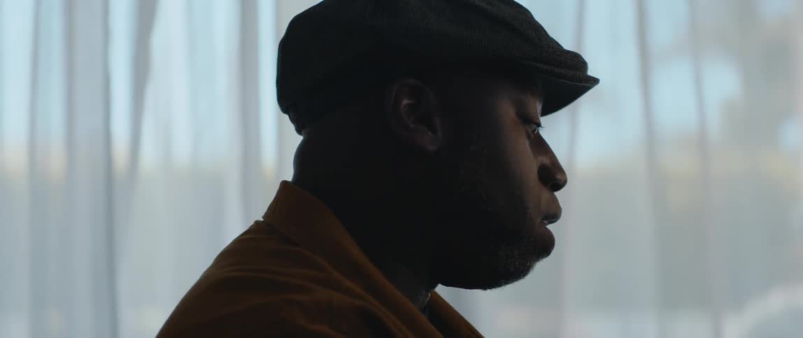 A young black man is singing in his house