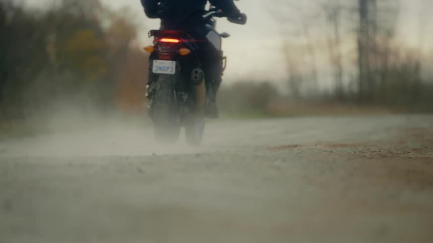 A person riding a motorcycle on a rural dirt road