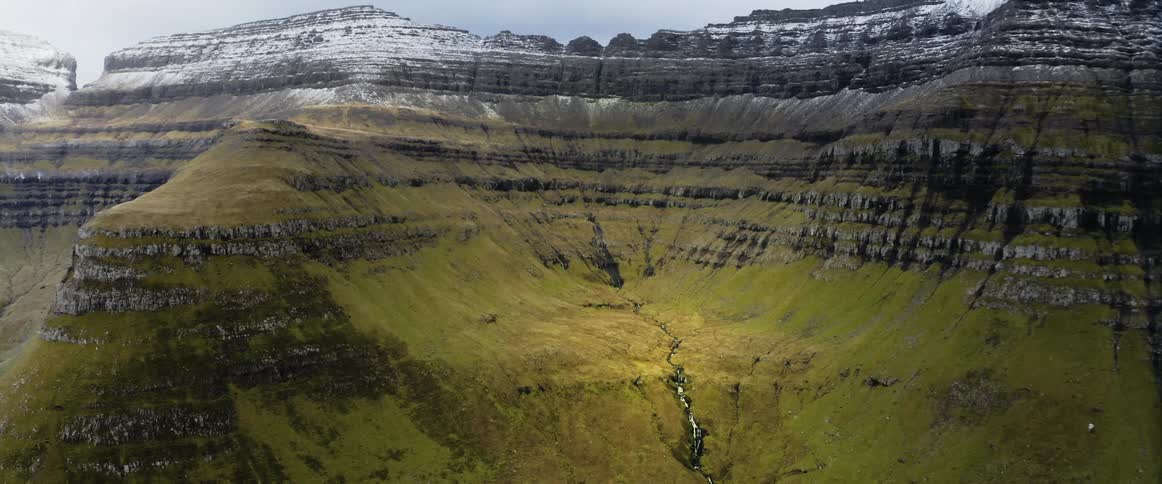 Aerial view of grass covered mountains is displayed