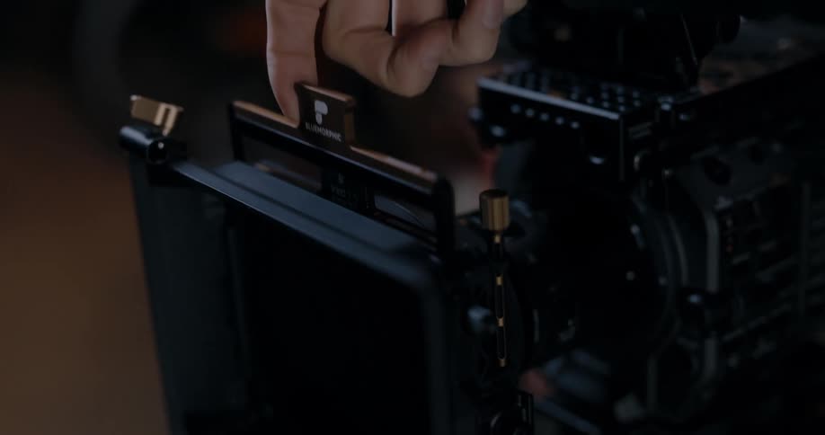 A person loading a filter onto a camera